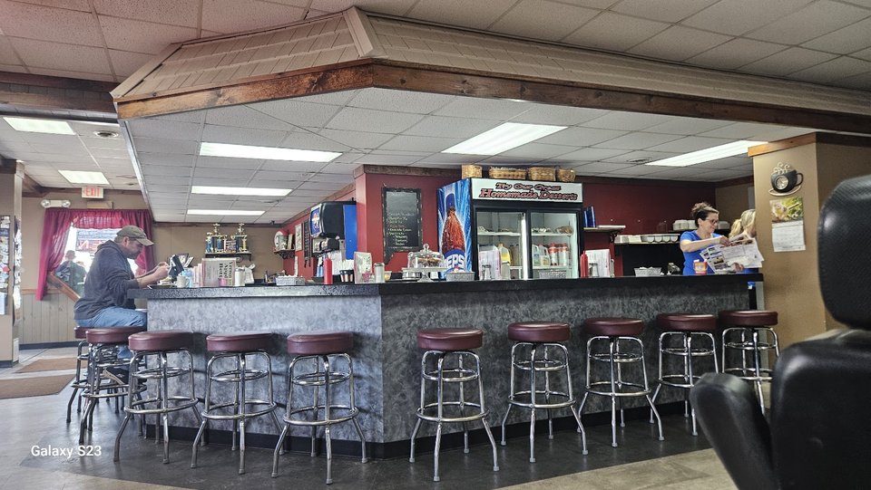 Coffee mugs beside a hearty diner meal.